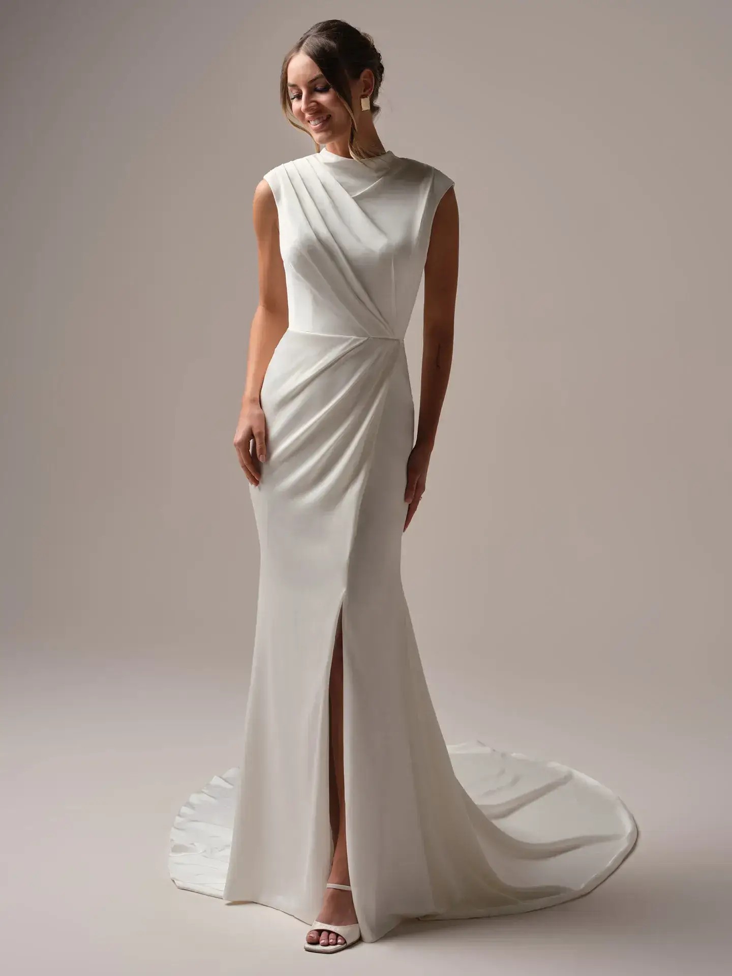 Model is wearing a sheath bridal dress with a high neckline by rebecca ingram