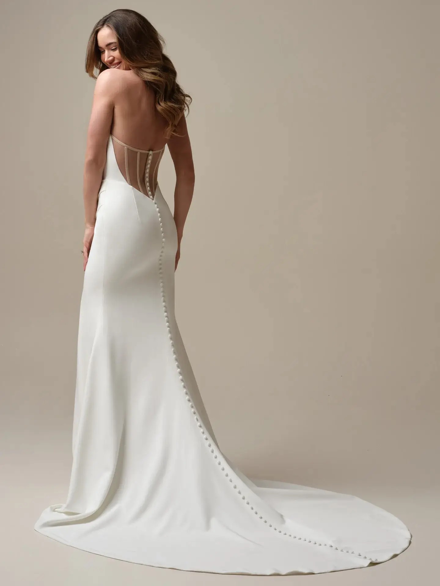 Model is wearing a crepe wedding dress with a basque waist by rebecca ingram