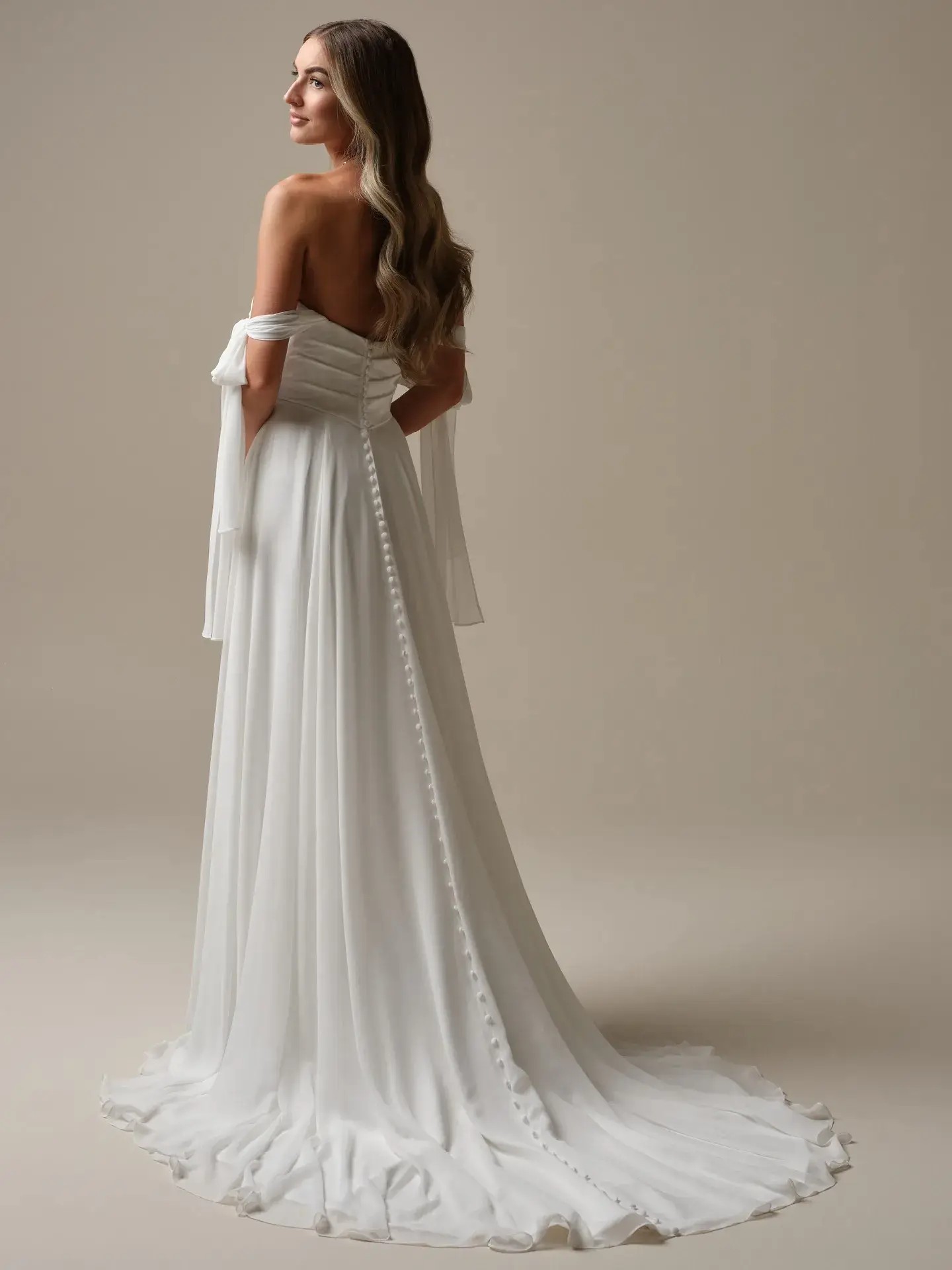 Model is wearing an A-line wedding dress with chiffon and satin fabrics by rebeca ingram