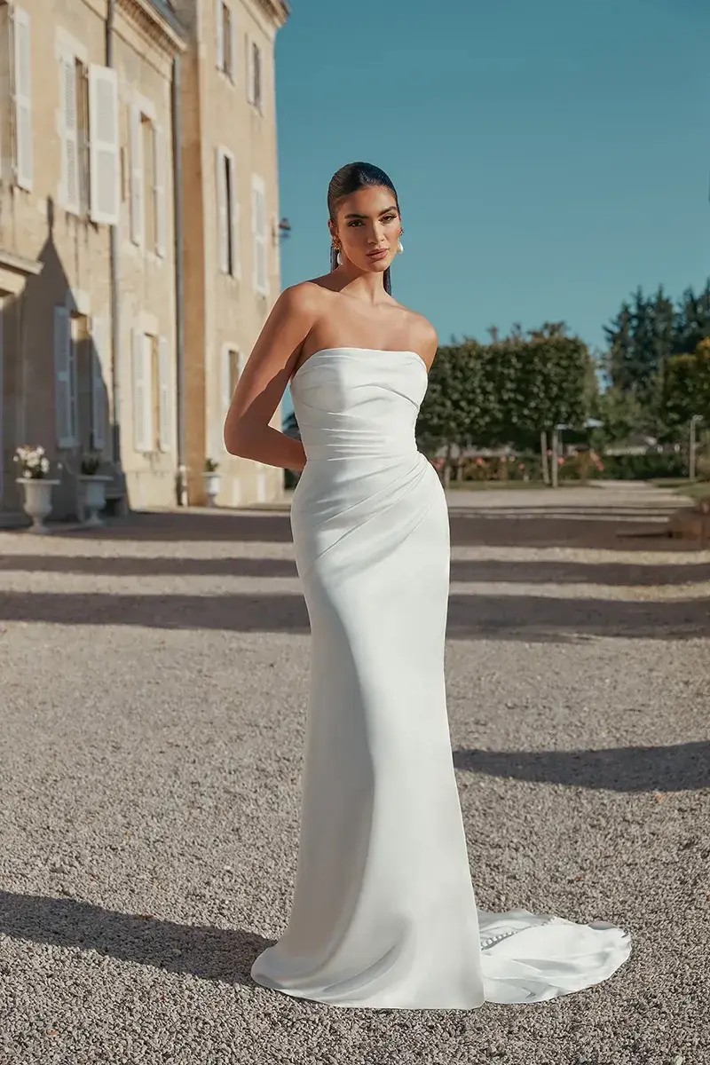 Model is wearing a fit and flare wedding dress with a ruched bodice by justin alexander