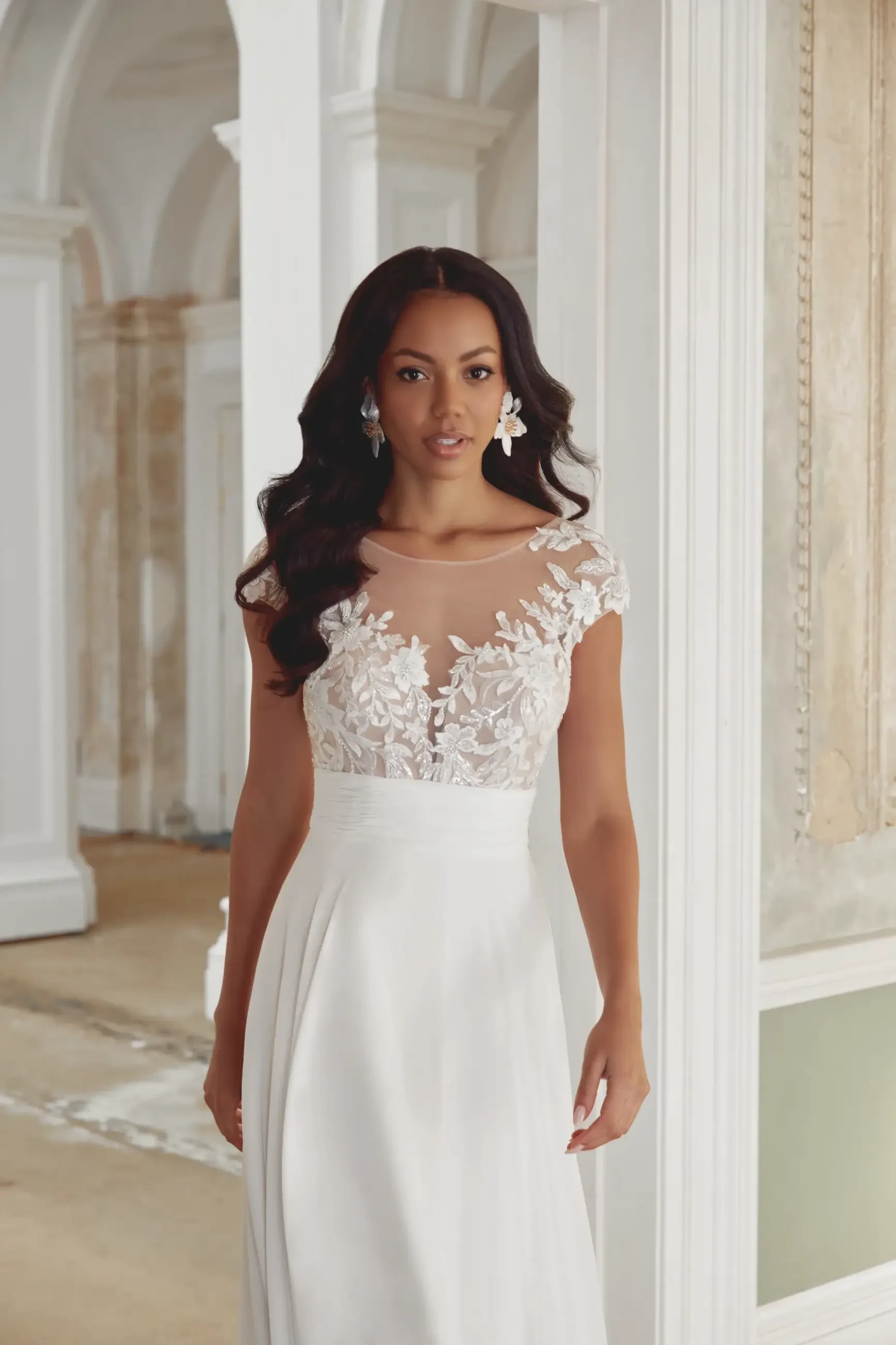 model is wearing an a-line chiffon bridal gown