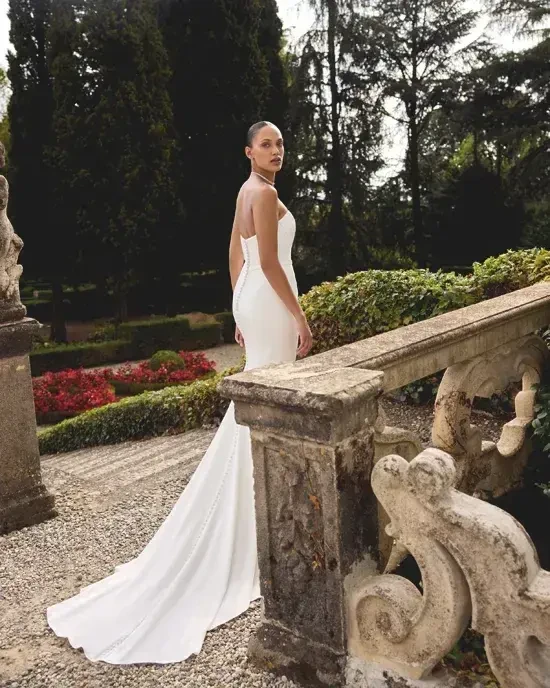 model is wearing a strapless minimalist fit and flare wedding gown