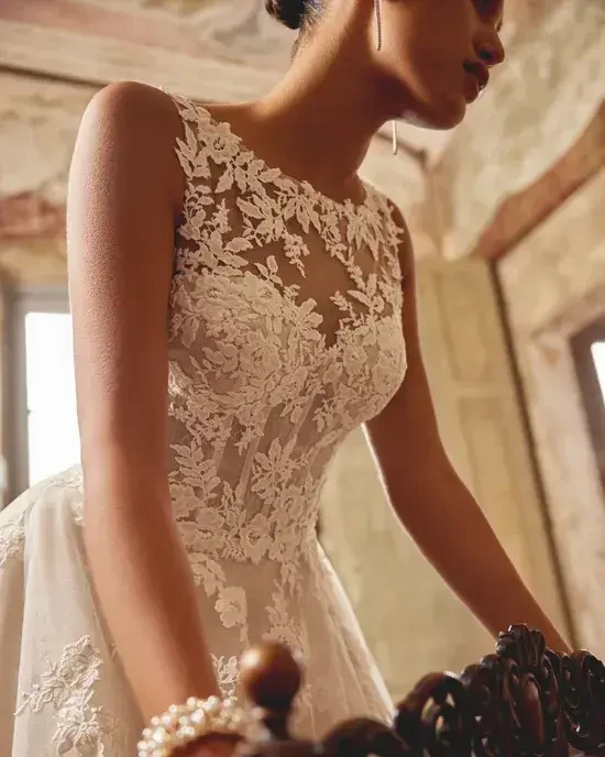 model is wearing a high neckline sleeveless a-line wedding dress