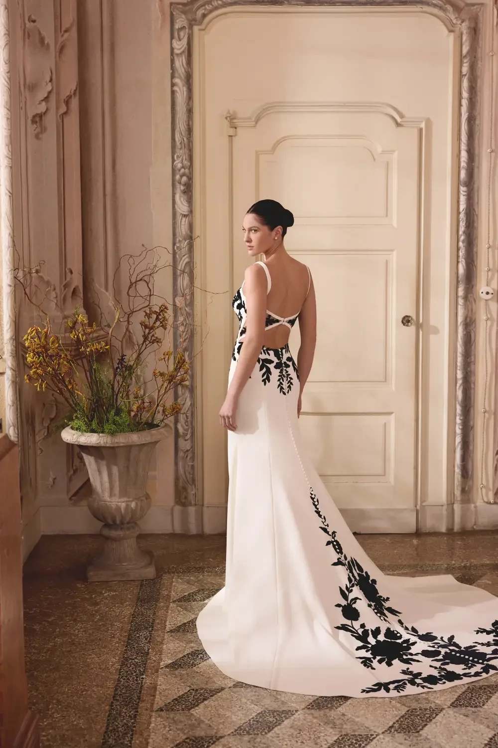 model is wearing a black and white floral bridal gown