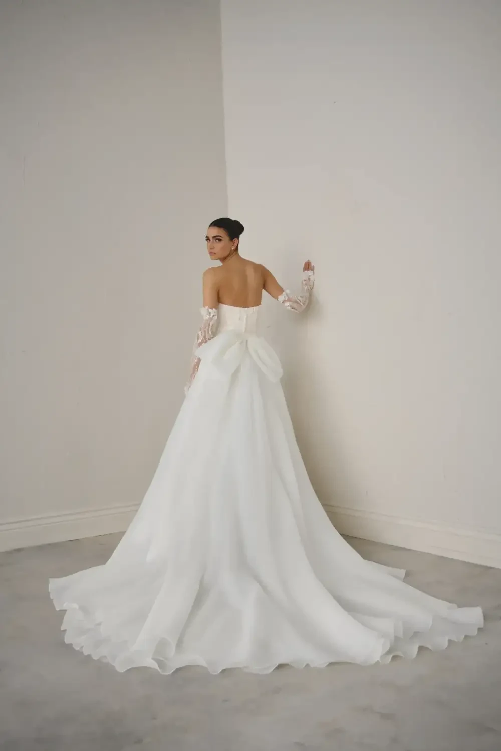 model is wearing a strapless ball gown with 3d floral appliques