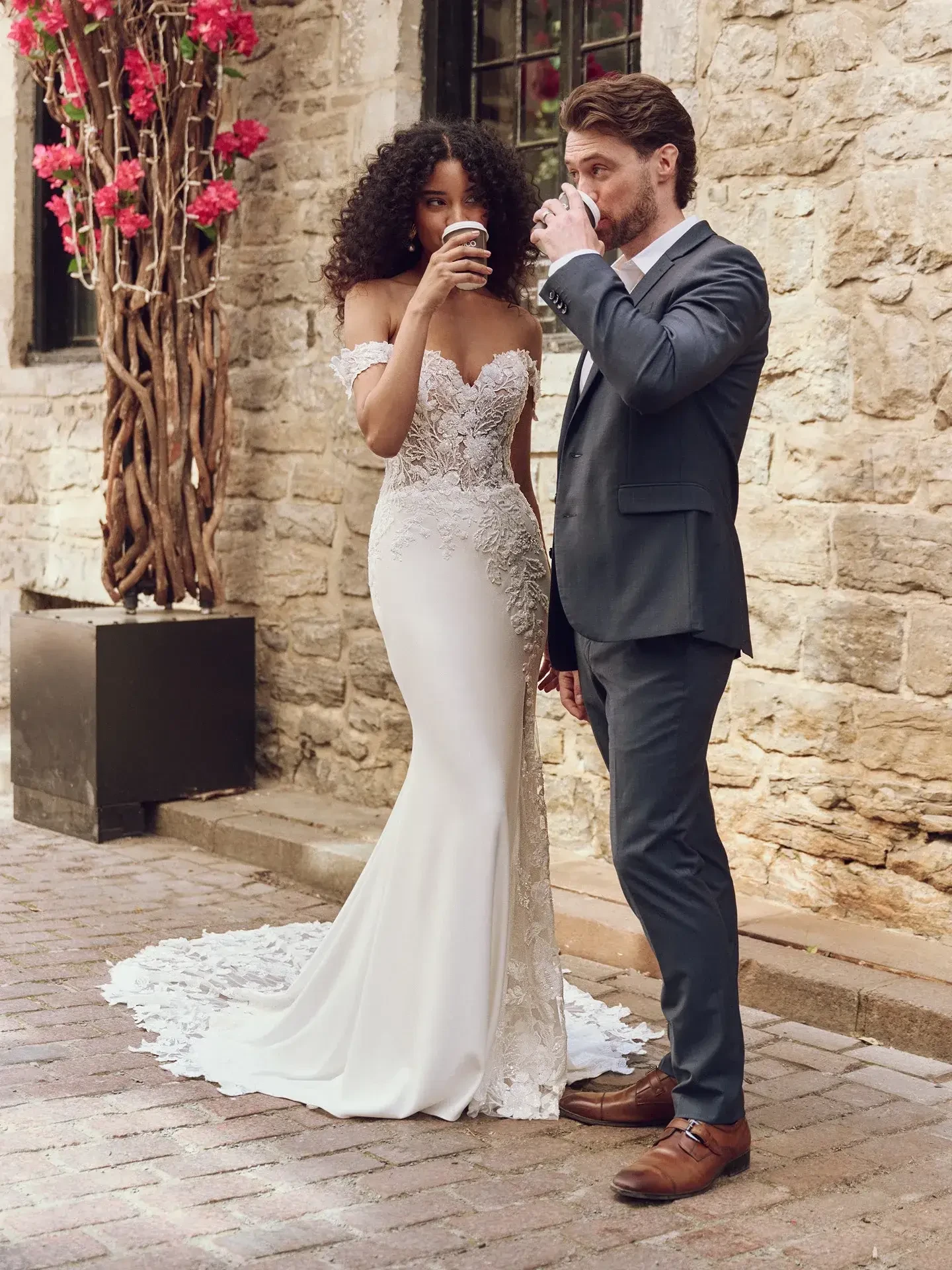 model is wearing an off the shoulder fit and flare wedding gown