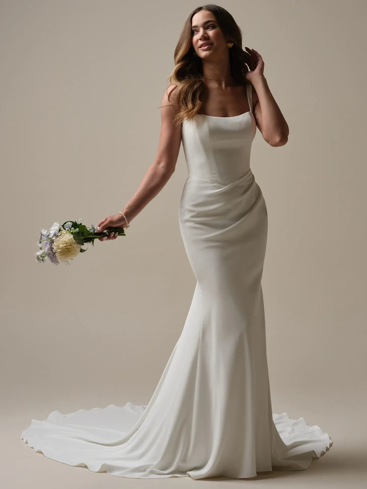 model is wearing a long sleeve crepe fit and flare wedding gown