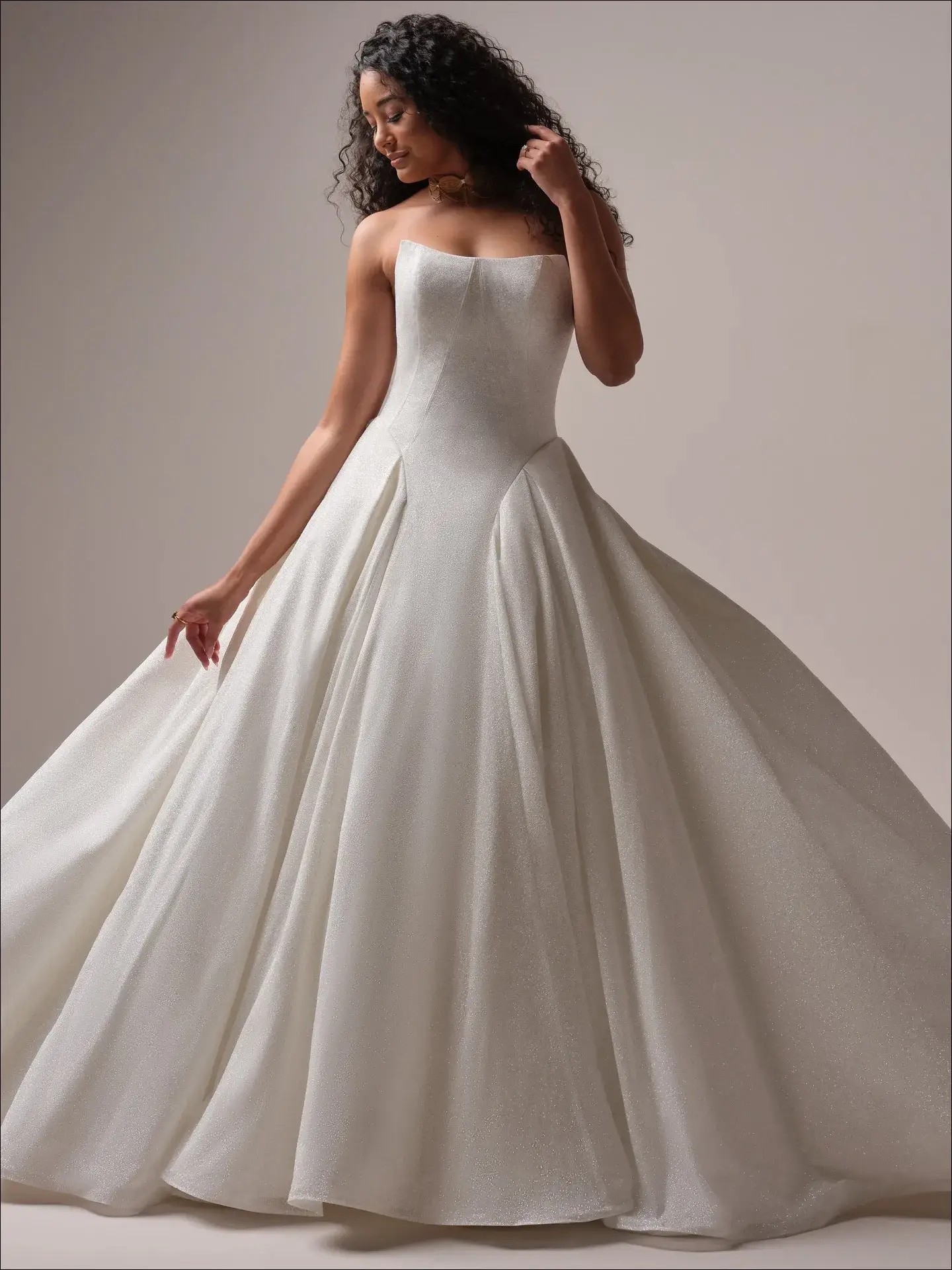 Model is wearing a shimmer ball gown wedding dress by maggie sottero