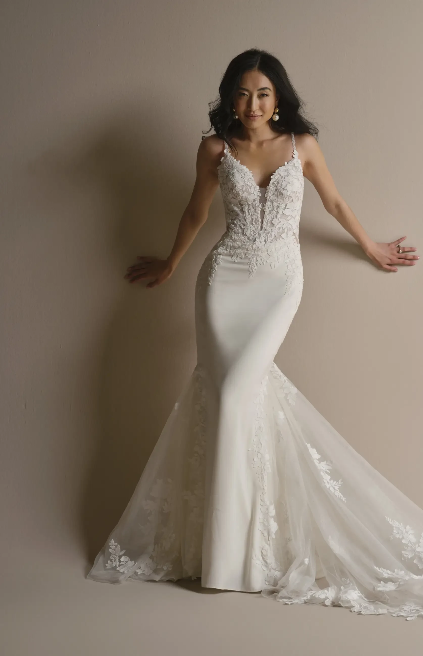 model is wearing a sleeveless fit and flare wedding dress