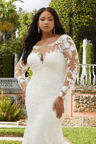 bride standing with lacy long sleeve mermaid wedding dress