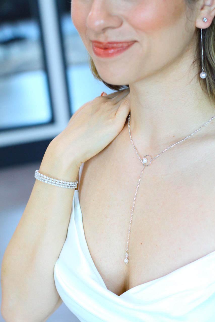 Bride smiling wearing pearl accessories