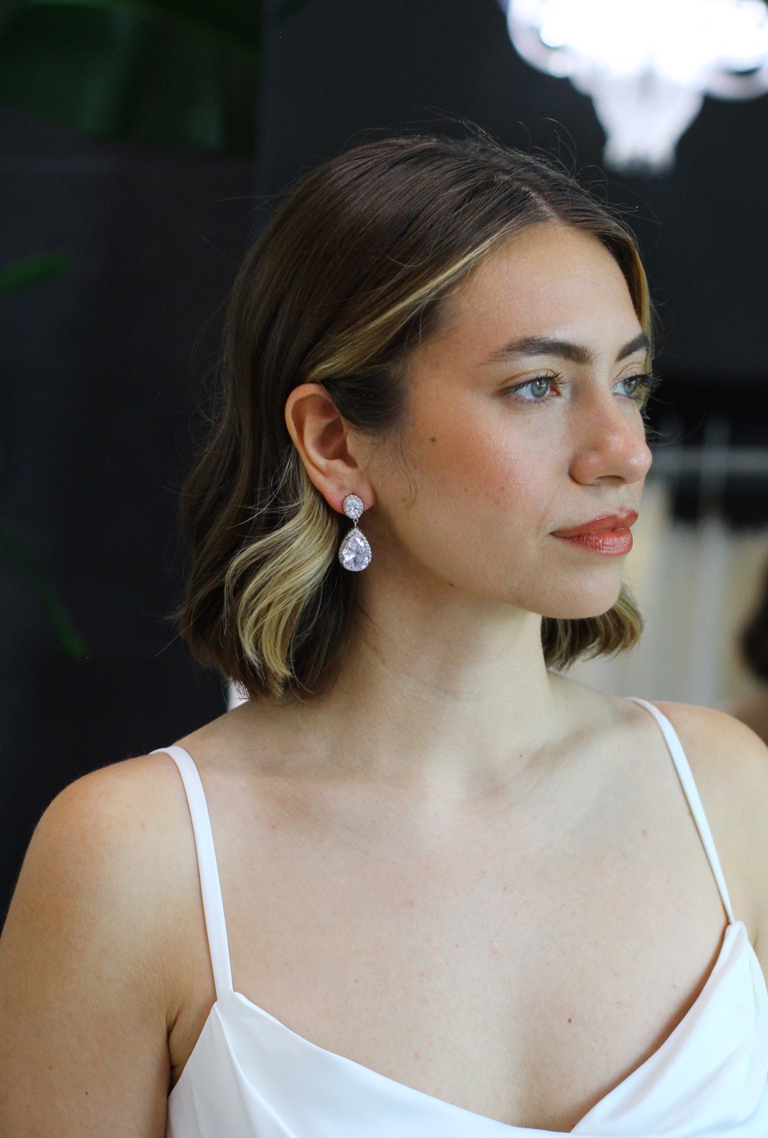 Bride wearing diamond earrings looking off into the distance