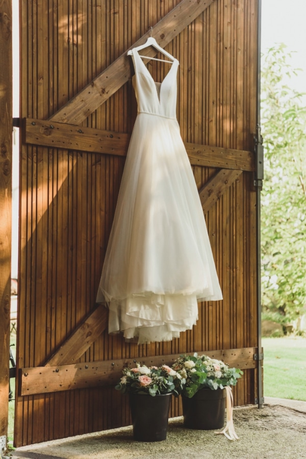 rustic wedding dress hanging on a barn door